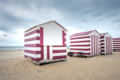 Beach hut on beach against sky