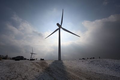 Windmill on field against sky