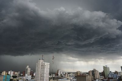 View of cityscape against cloudy sky