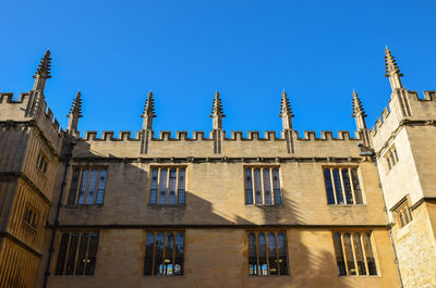 Low angle view of buildings against clear blue sky