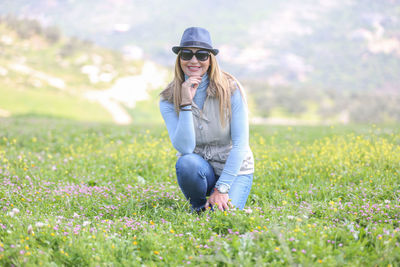 Portrait of young woman wearing sunglasses on field