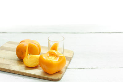 Close-up of persimmon on cutting board over table