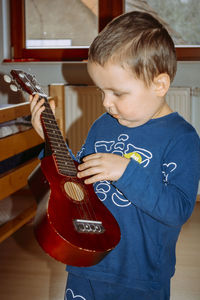 Boy playing ukulele guitar