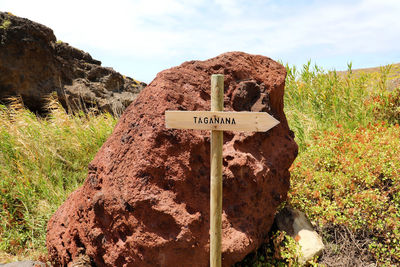 Information sign on rock against sky