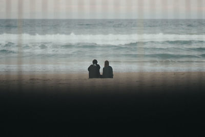 People at beach against sky