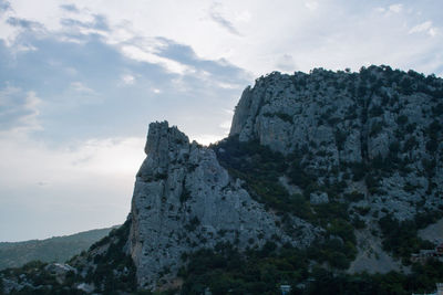 Low angle view of cliff against sky