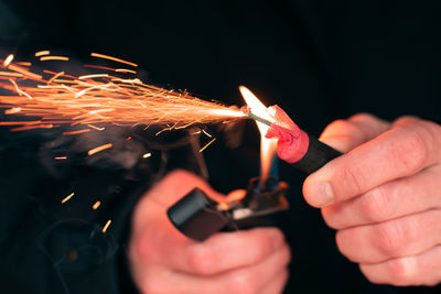 Close-up of hand holding lit candles