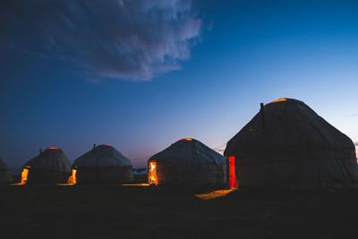 Scenic view of yurts against sky at night