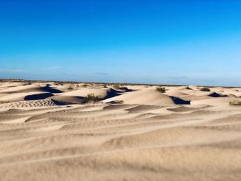 Scenic view of desert against clear blue sky