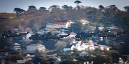 Military helicopters flying over townscape