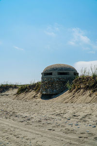 Abandoned building at beach against sky