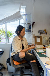 Portrait of young woman sitting at home