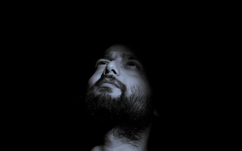 Close-up of man looking away in darkroom