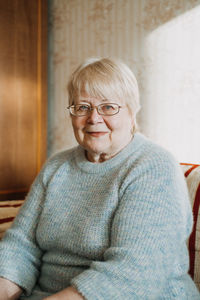 Portrait of smiling senior sitting on floor