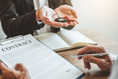 Midsection of man reading book on table