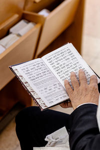 Low section of man holding book