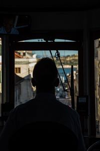 Rear view of silhouette man sitting in bus