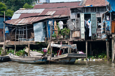 Houses by river against buildings