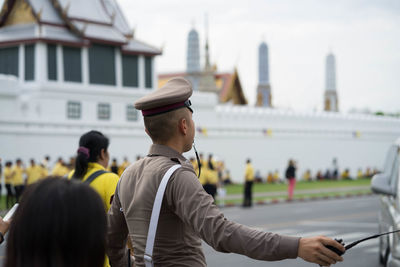 Man in police uniform guiding traffic on street