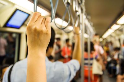 Cropped hand of woman in train