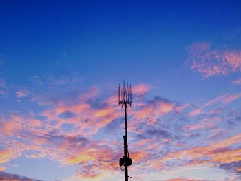 Low angle view of silhouette communications tower against sky during sunset