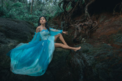 Young woman standing in forest