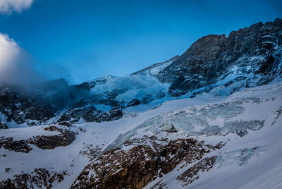 Scenic view of snow covered mountains against sky