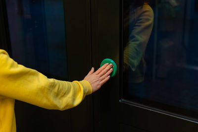 Midsection of man standing by window