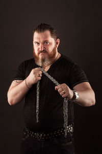 Man holding cigarette against black background