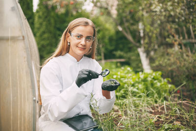 Portrait of a smiling young woman holding plants