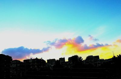 Silhouette of buildings against blue sky