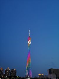 Low angle view of illuminated tower against clear blue sky