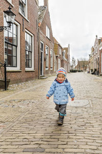 Full length of baby girl walking on street in town