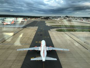 High angle view of airplane on airport runway against sky