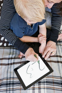 Grandmother and grandson using digital tablet