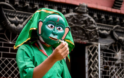 Low angle view of man wearing mask against temple
