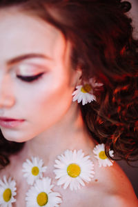 Close-up of beautiful young woman wearing flowers and make-up