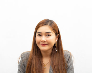 Portrait of smiling woman against white background