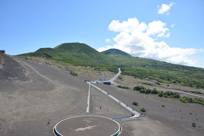 Scenic view of road by mountain against sky