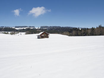 Scenic view of snow covered field against sky