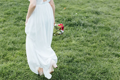 Low section of woman standing on field