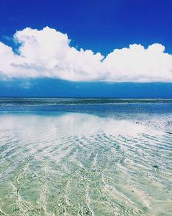 Scenic view of calm sea against cloudy sky