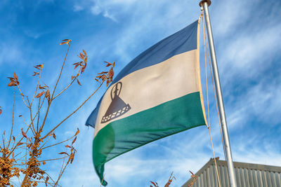 Low angle view of flag against blue sky