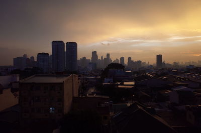 View of cityscape against cloudy sky