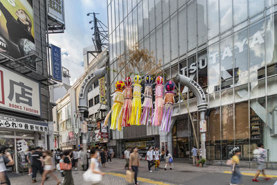 People walking on street amidst buildings in city