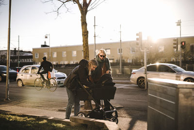 Mothers walking with baby stroller along street