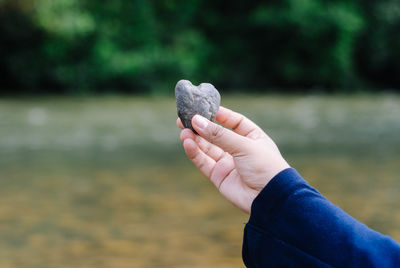 Close-up of hand holding heart shaped stone