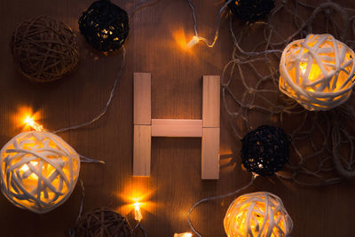 Directly above shot of letter h blocks and illuminated lights on wooden table