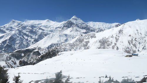 Scenic view of snow covered mountains against sky