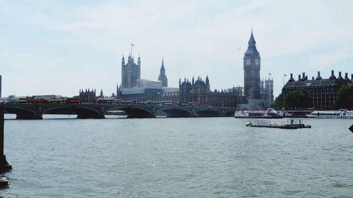 Bridge over river in city against sky